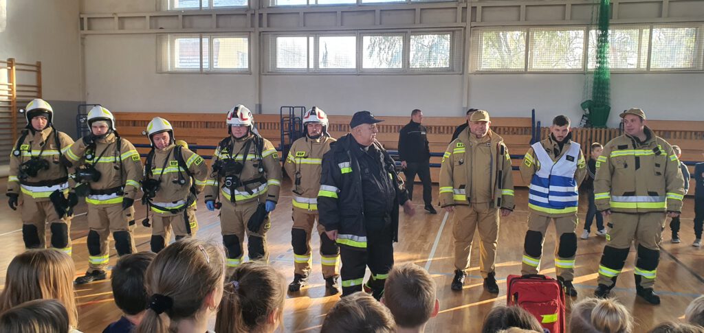 uczniowie i strażacy na sali gimnastycznej 