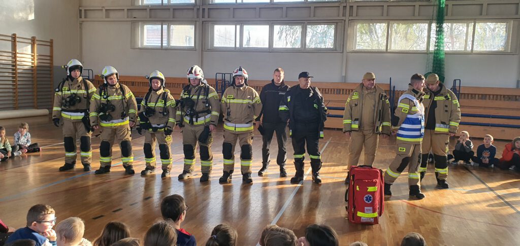 uczniowie i strażacy na sali gimnastycznej 